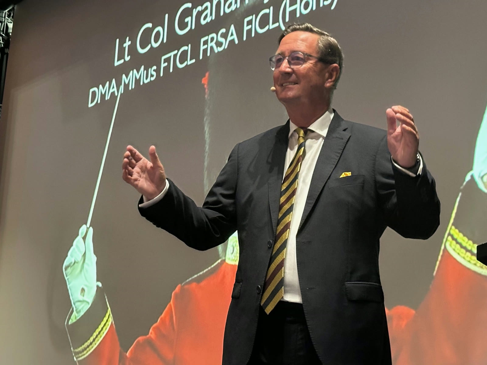 Graham Jones speaking on stage to a live audience
